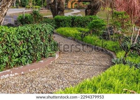 Reflexology walkway path with green trees and grass in a park. Morning sunlight on walkway- Stock Photo