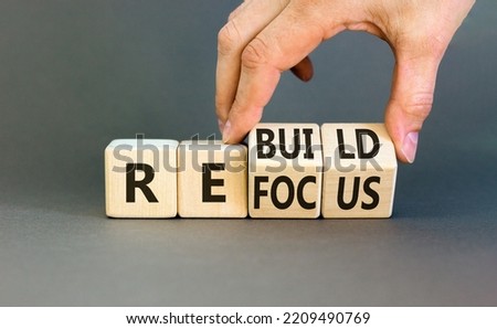 Refocus and rebuild symbol. Businessman turns cubes and changes the word 'refocus' to 'rebuild'. Beautiful grey table, grey background. Business refocus and rebuild concept. Copy space. Stockfoto © 