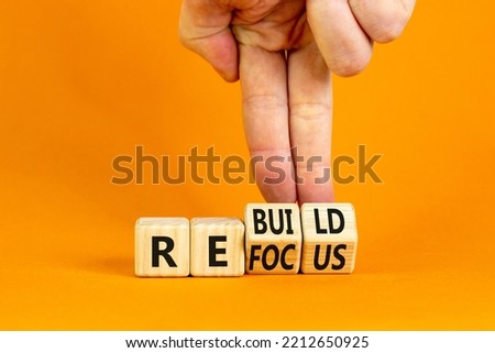 Refocus and rebuild symbol. Businessman turns cubes and changes the word 'refocus' to 'rebuild'. Beautiful orange table, orange background. Business refocus and rebuild concept. Copy space.