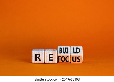 Refocus and rebuild symbol. Turned cubes and changed the word 'refocus' to 'rebuild'. Beautiful orange table, orange background. Business refocus and rebuild concept. Copy space.