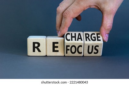 Refocus And Recharge Symbol. Businessman Turns Cubes And Changes The Word 'refocus' To 'recharge'. Beautiful Grey Table, Grey Background. Business Refocus And Recharge Concept. Copy Space.