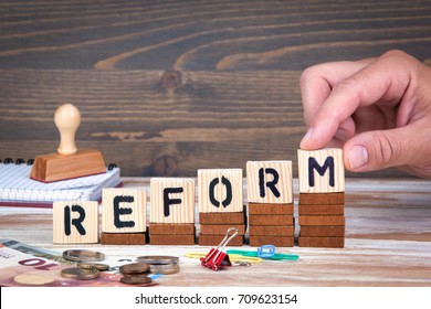 Reform concept. Wooden letters on the office desk, informative and communication background