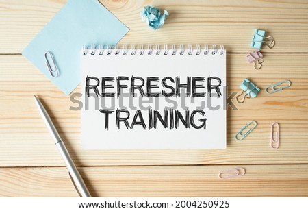 Refresher Training text on paper on wooden background.