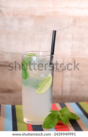 refreshing alcoholic drink with berries, ice vodka and gin, lemon peel served in glass cup on the counter on blurred background iamge