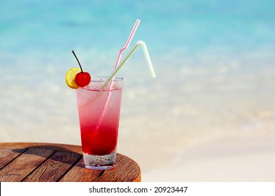 Refreshing cocktail on a beach table