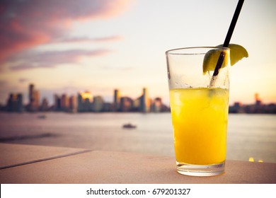 Refreshing cocktail with sunset and hudson river in the background