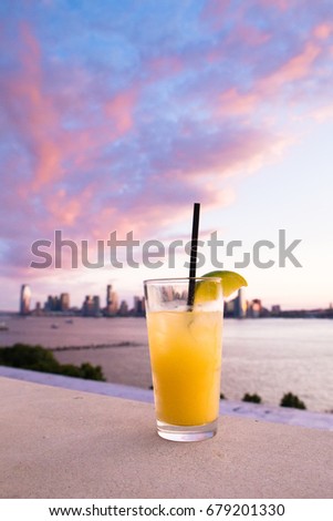 Refreshing cocktail with sunset and hudson river in the background