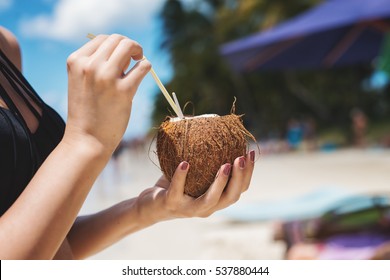 Refreshing coconut cocktail  in woman hands.