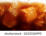 Refreshing cola with ice as background, macro view