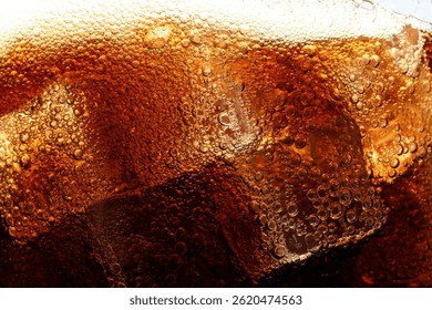 Refreshing cola with ice as background, macro view