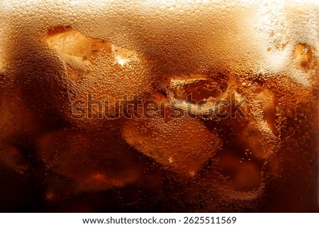 Refreshing cola with ice as background, macro view