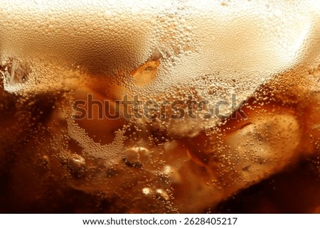 Refreshing cola with ice as background, macro view