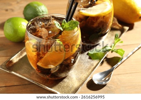 Refreshing Cuba libre cocktail with mint on wooden table, closeup