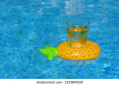 Refreshing Drink Floating On An Inflatable Pineapple In Swimming Pool. Tropical Holiday Vibes