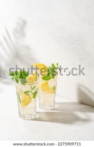 Refreshing drink with ice, lemon and mint. Cold lemonade on white background