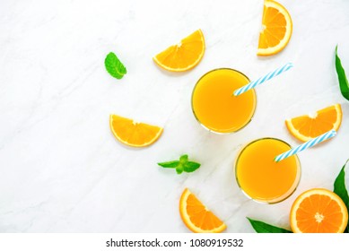 Refreshing Drinks For Summer, Cold Sweet And Sour Tropical Orange Juice With Ice Cubes In The Glasses On White Marble Countertop, Overhead View