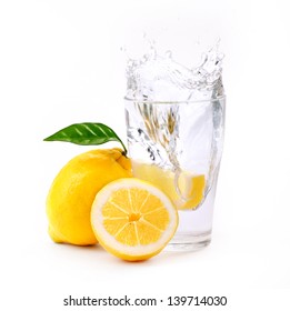 Refreshing Glass Of Water With Splashed Lemon Isolated On White