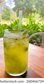 Refreshing green grape drink with mint on wooden table in restaurant