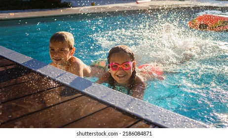 Refreshing at heat weather. Cheerful children in googles smiling while playing in swimming pool at sunny day, active vacation and healthy lifestyle, happy summertime, banner format - Shutterstock ID 2186084871