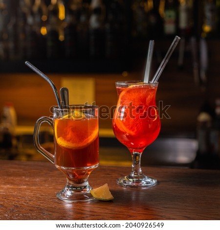 Refreshing hot ginger tea and grog drink
in glass cups served on wooden table with lemon slice in cafe in fall season 