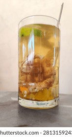 Refreshing iced lemon tea served in a tall glass with ice cubes and lemon slices.