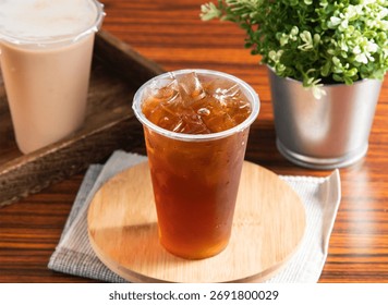 Refreshing Iced Winter Melon Tea on wooden board, perfect for a hot day, featuring a cool drink and a vibrant plant for a calming, natural feel, ideal refreshment