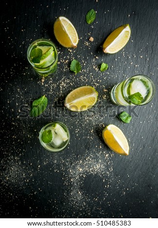 Refreshing lime mojito or tequila with ingredients for it - lime, mint, brown cane sugar. Top view,copy space