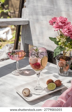 A refreshing lychee lime mocktail in a glass, garnished with fresh rosemary and lime on a white wooden table. Perfect for non-alcoholic beverage, summer cooling, and healthy lifestyle concepts.
