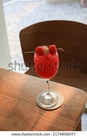 Refreshing lychee and raspberry cocktail with iced and fresh fruit in glass. Summer drink.