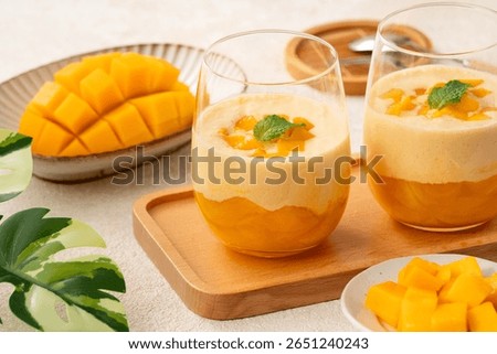Refreshing mango mousse dessert served in glass cups, topped with mint leaves, perfect for summer.