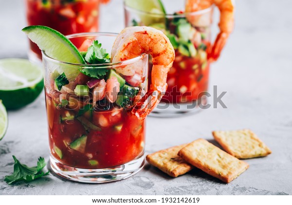 Refreshing Mexican Shrimp\
Cocktail with lime in glass on gray stone background, copy\
space.