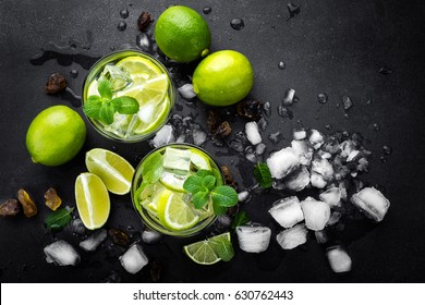 Refreshing Mint Cocktail Mojito With Rum And Lime, Cold Drink Or Beverage With Ice On Black Background, Top View