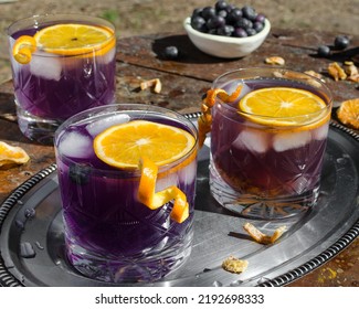 Refreshing Purple Drink With Blueberries Ice And Orange Slice. Drink Concept