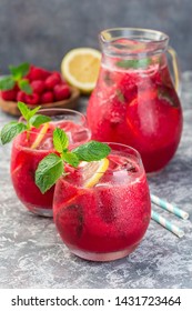Refreshing raspberry, lemon and mint lemonade with sparkling water in a glass, vertical