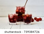 Refreshing sangria or punch with fruits in glasses and pitcher.  Traditional summer drink beverage. Red wine, strawberries, oranges, lemon, and green apple. On a wooden rustic table with copy space.
