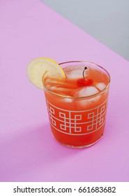 Refreshing Shirley Temple Cocktail On A Pink Table. Garnished With A Lemon And Cherries With A Stem. This Is A Classic Recipe For A Non-alcoholic Summer Drink.