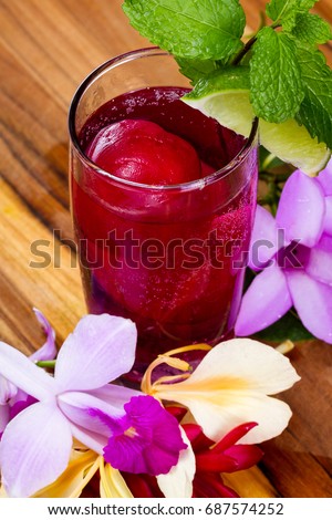 refreshing sparkling cocktail with frozen red juice garnished with beautiful wildflowers