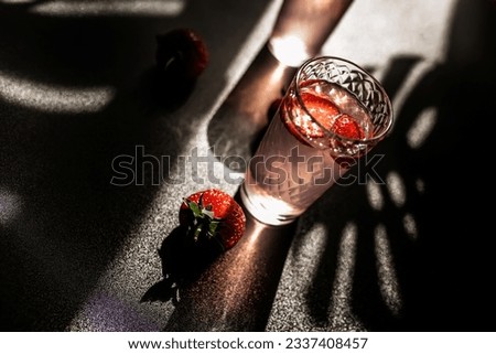 Refreshing strawberry lemonade. Cool and fruity beverage with a hint of citrus. Glass filled with ice-cold strawberry and lemon juice on a dark background
