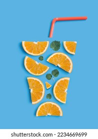 Refreshing summer cocktail concept. Creative flat lay arrangement of orange slices, fresh mint leaves and drinking straw in the shape of a glass with refreshing orange juice on light blue background. - Shutterstock ID 2234669699