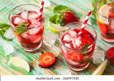 Refreshing summer drink with Strawberry in jug and glasses on the vintage wooden table