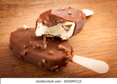 Refreshing summer food, icy cold dessert and frozen snack concept with close up on vanilla, hazelnut and chocolate ice cream bars, stacked together with the one on top bitten off on wood background - Powered by Shutterstock