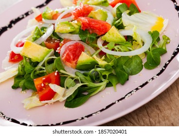 Refreshing Summer Salad With Avocado, Grapefruit, Tomatoes, Corn Salad On Pink Plate