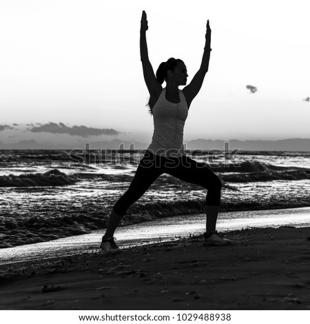 Refreshing wild sea side workout. Silhouette. Full length portrait of healthy woman in sportswear on the seacoast workout