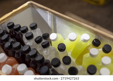 Refreshment cold drink plastic bottle filled with sweet colorful fruit juice and tea inside ice box cooler for thirsty summer party and celebration with fresh feeling
