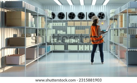Refrigeration warehouse. Woman storekeeper with laptop. Worker inside industrial refrigerator. Girl examines boxes on racks. Girl in work uniform in industrial refrigerator. Freezer chamber
