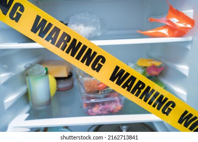 Refrigerator Closed With A Protective Tape With The Inscription Warning. The Concept Of Hunger And Overeating Or Pathogenic Microbes And Spoiled Food