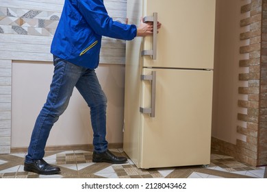 refrigerator delivery,buy a new refrigerator, a man places a refrigerator in the kitchen