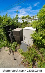 Refrigerator illegally dumped on the side of the road - Shutterstock ID 2202822455