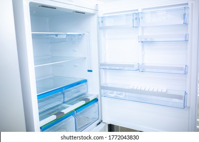 Refrigerator. Open door of an empty fridge. Household appliances in the store. Electrical equipment and household goods. Kitchen appliances in the mall.