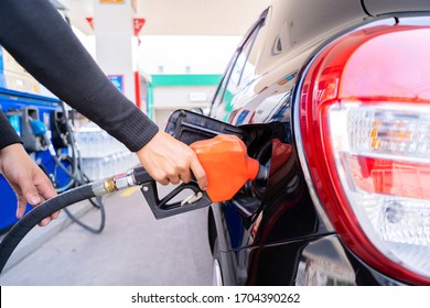 Refuel cars at the fuel pump. The driver hands, refuel and pump the car's gasoline with fuel at the petrol station. Car refueling at a gas station Gas station - Shutterstock ID 1704390262